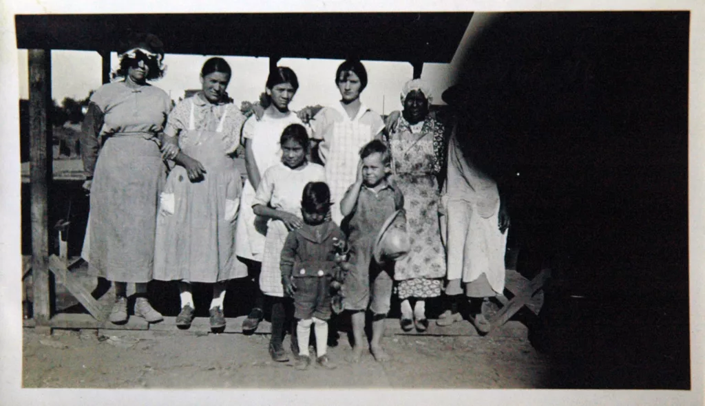 L-R Back, Andrea Esparza Limon, Petra Limon Olvera, Maria Cruz Limon, Maria Sixta Limon Newton, names unknown (child with head down is Margarito Olvera), in front of the Santa Fe Railroad labor camp kitchen where they worked, Newton, Kansas.